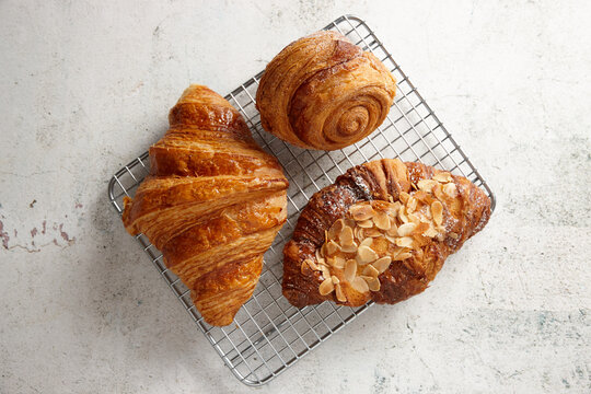 Looking down on three pastries on a cooling rack on marble background