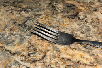close up of a fork on a marble counter