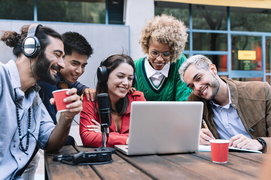 Creative coworker professional team of friends on online video call with laptop, microphone and digital tech