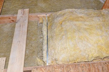 Glass wool placed on pipes in domestic ventilation with heat recovery, pipes placed on a roof truss.