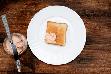 On toast, creamy pasta on a white plate. Dark wooden background. Food concept. A quick snack. Top view.