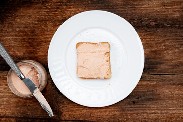 On toast, creamy pasta on a white plate. Dark wooden background. Food concept. A quick snack. Top view.