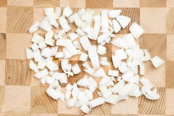 chopped onion on a wooden board. Wooden board in the form of a chessboard. Preparation for cooking. Top view.