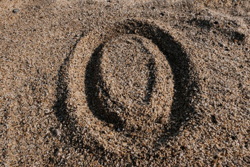 Fototapeta na wymiar English alphabet. Sand on the beach. The letter O