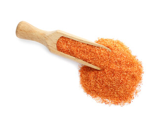 Wooden scoop with orange salt on white background, top view