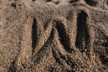 English alphabet. Sand on the beach. The letter W