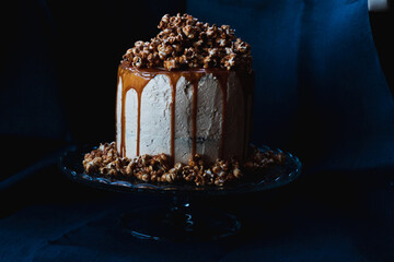 Caramel cake with popcorn on top on the dark background