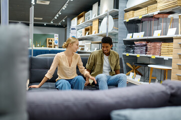 Couple choosing sofa for home in store