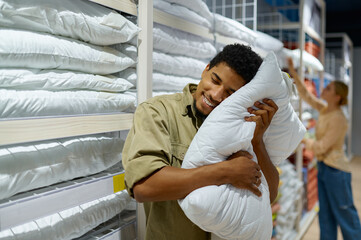 Man purchaser holding pillow in textile shop