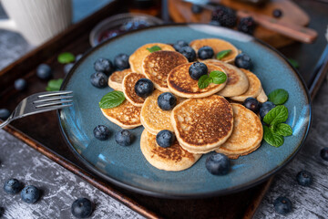 Mini pancakes on a plate with blueberries, jelly and butter. Protein pancakes for smaller bites....