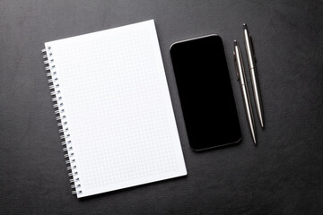 Notepad and smartphone with blank screen