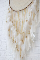 White dreamcatcher hanging on white wall