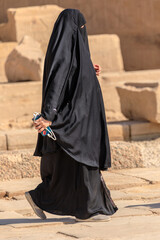 Muslimisch schwarz verschleierte Frau mit einem Handy in der Hand