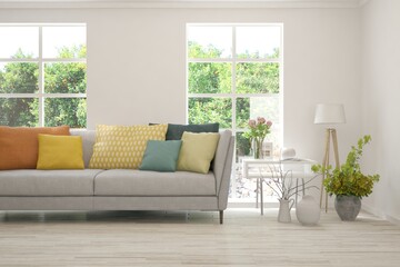 Minimalist living room in white color with sofa and summer landscape in window. Scandinavian interior design. 3D illustration
