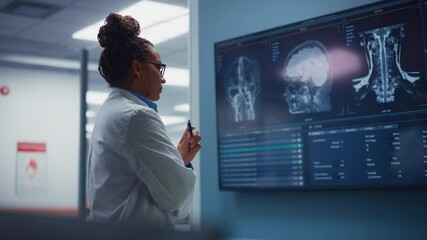 Medical Science Hospital: Confident Black Female Neurologist, Neuroscientist, Neurosurgeon, Looks at TV Screen with MRI Scan with Brain Images, Thinks about Sick Patient Treatment Method. Saving Lives - Powered by Adobe