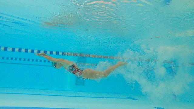 Woman swimmer by the pool. An underwater photo during a sports swimming training session.