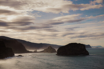 landscape of cliffs at sunset with hermitage of Gaztelugatxe in the background