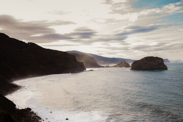 landscape of cliffs at sunset with hermitage of Gaztelugatxe in the background