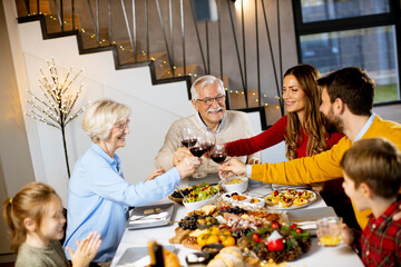 Happy family having dinner with red wine at home