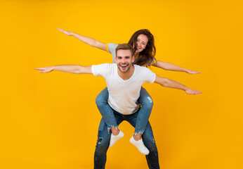 Spread your wings and fly away. Happy woman enjoy riding piggyback on guy. Enjoy every moment