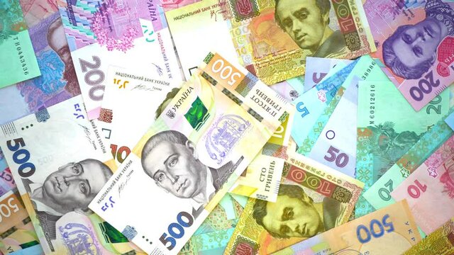 Ukrainian hryvnia money is spinning on the table. Many hryvnia currency banknotes of various denominations. National Bank of Ukraine (NBU). Top view. Close-up