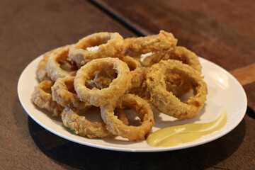 Fried onions on plate with mustard sauce