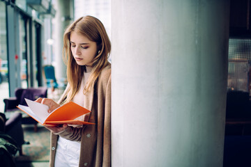 Thoughtful female student reading book