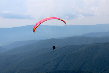 Paragliding in clouds above the mountines