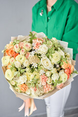 Beautiful large bouquet of mixed flowers in woman hand. Handsome fresh bouquet. Small flower shop and Flowers delivery.