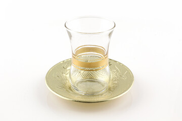 Empty turkish tea glass and metallic plate isolated on white. Traditional and authentic