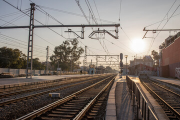 Obraz na płótnie Canvas Train tracks and power pylons at a Spanish train station near Barcelona. rails and sleepers close up.