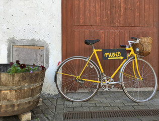 Fototapeta na wymiar bicicleta amarilla con cesta y rótulo aparcada en la puerta del museo IMG_5294-as22