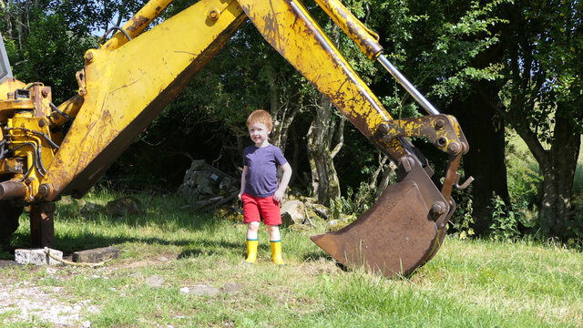 Young boy playing in an old Yellow Digger on the farm