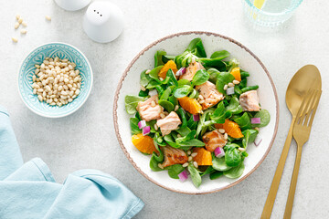 Christmas salmon orange salad with pine nuts, red onion and corn salad lettuce