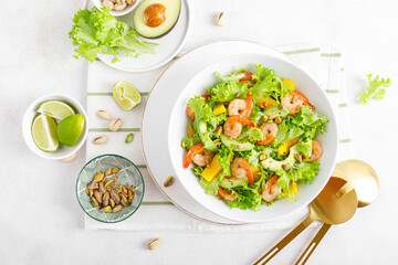 Grilled shrimp salad with avocado, mango, lettuce and pistachios, dressed with lime. Healthy food. Ketogenic diet. Top view.