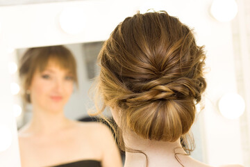 Fototapeta premium The stylist performs the hairstyle, hair styling in the salon.