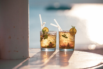 Two mojito cocktails against the sunset light on the beach