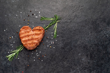 Heart shaped grilled beef steak with arrow for valentine's day on stone background with copy space...