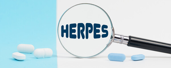 On a blue and white background, there are pills and a magnifying glass, inside of which it is...