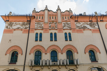 Obraz premium The facade of a tenement house with windows and the coat of arms of the city of Krakow.