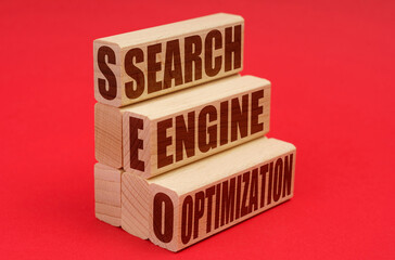 On a red background, wooden blocks with the inscription - Search engine optimization