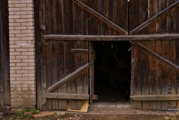 Fototapeta na wymiar Wrota i furtka we froncie starej zabytkowej drewnianej stodoły . Gate and wicket in front of an old historic wooden barn. 