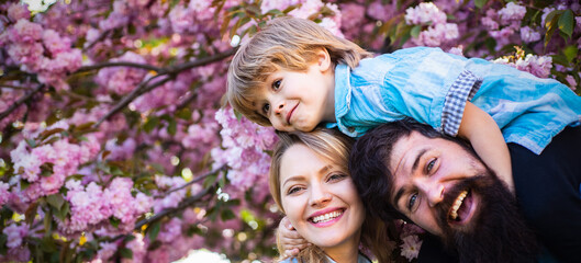 Spring blossom banner with happy family. Mother father and son hugging in the spring park. Family outdoors. Happy family.