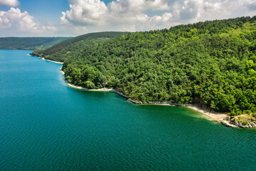 Aerial view of Bakotinskaya bay, Ukraine, scenic view of the Dniester river, rocks, forests and mountains above the blue water of the lake, sunny day