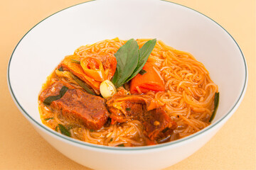Hu tieu bo kho; Vietnamese Beef Stew with rice noodles; Vietnamese food isolated on beige background; close-up