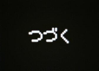 The japanese text To be continued (Tsuzuku in Hiragana characters), old 8-bit pixellated retro characters on a fake computer screen.

