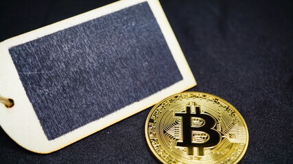 Wooden blackboard without writings, with Bitcoin gold coin. black background. copy space