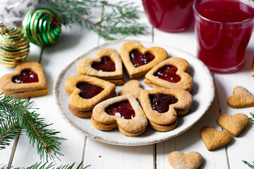 Dessert for breakfast: Delicious cookies with cherry jam in the shape of a heart on a plate on a white background. Close-up