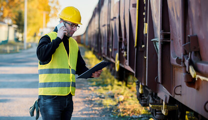 Shipping by rail. Supervisor making inspection of cargo in the freight wagon. Transportation concept
