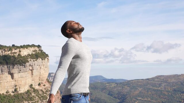 Atractive man with black skin breathing fresh air in nature